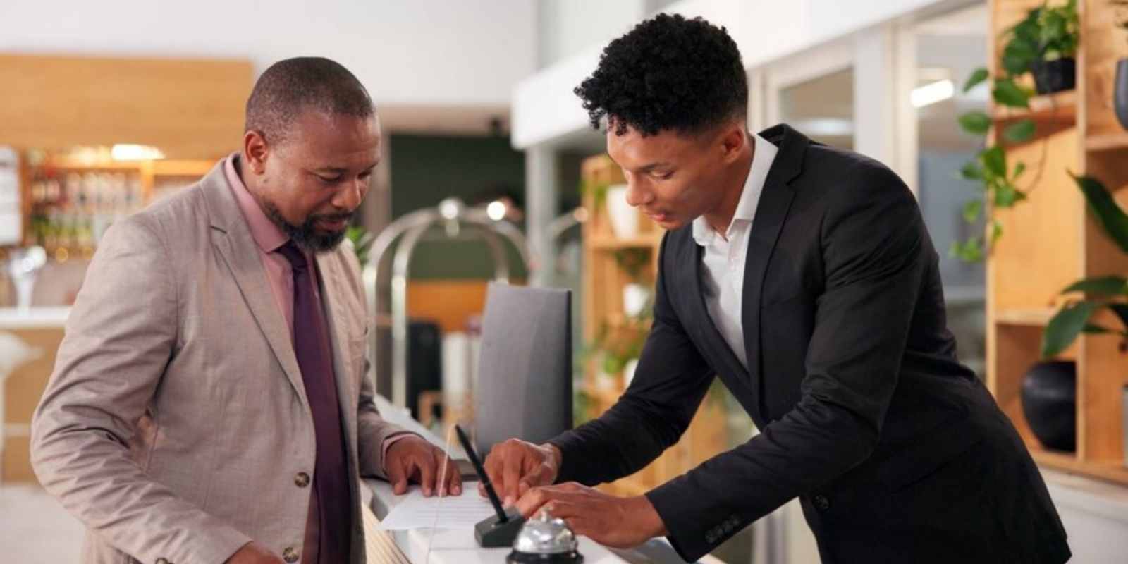 Concierge Assisting Resident at Reception Desk