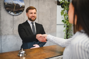 Concierge Shaking Hand with Guest at Front Desk