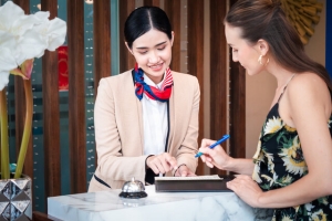 Female Concierge Assisting Resident Check-In Register Information